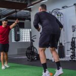 Trener personalny pracuje z klientem na siłowni Praga Południe