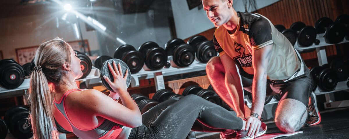Trener personalny pracuje z klientem na treningu siłowym