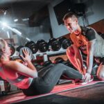 Trener personalny pracuje z klientem na treningu siłowym